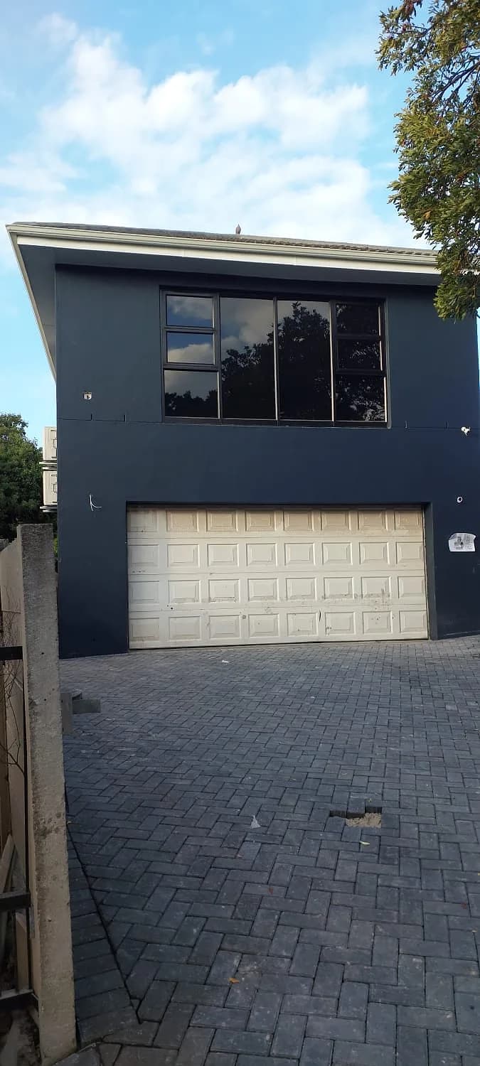 Charcoal painted double storey with garage and paved driveway