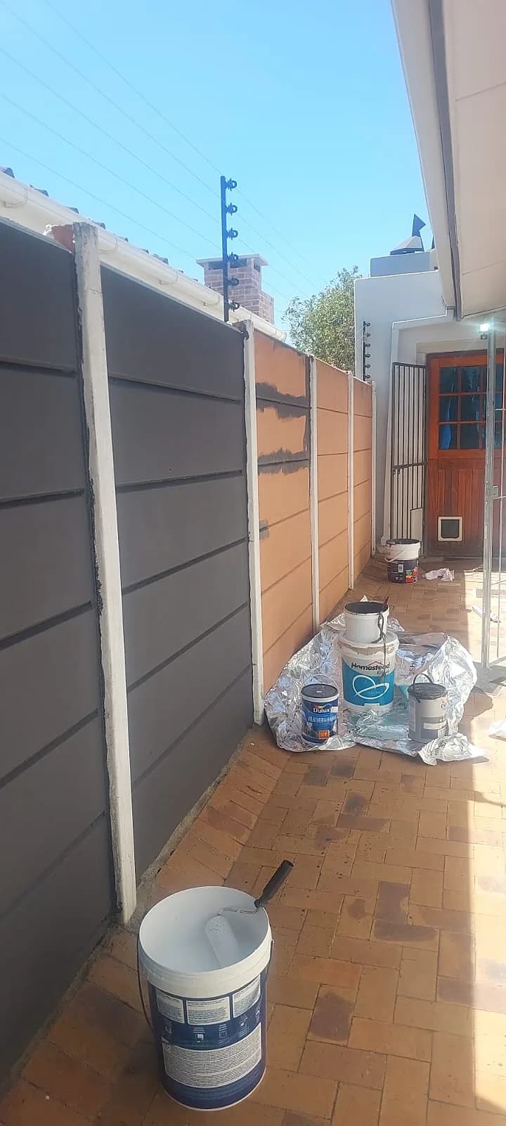 Courtyard fence painting with paint tins on site