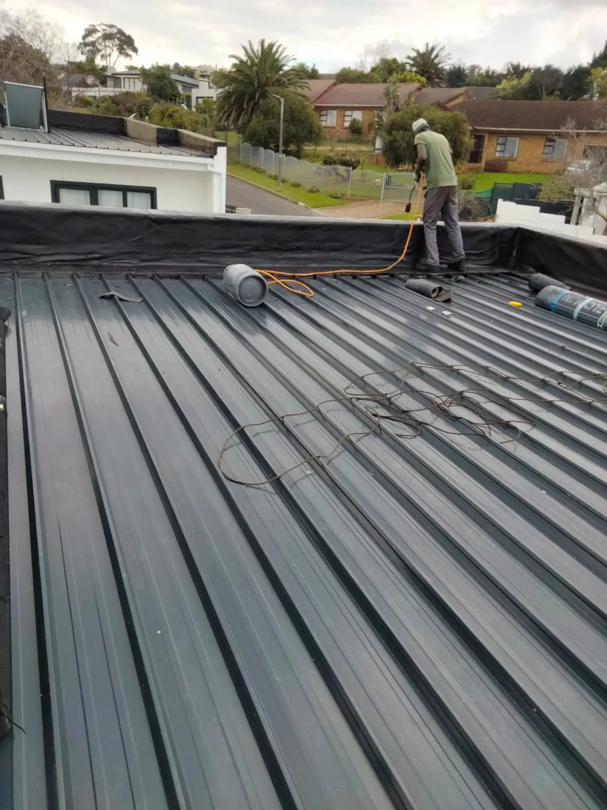Waterproofing membrane rolls on a metal roof ready for application
